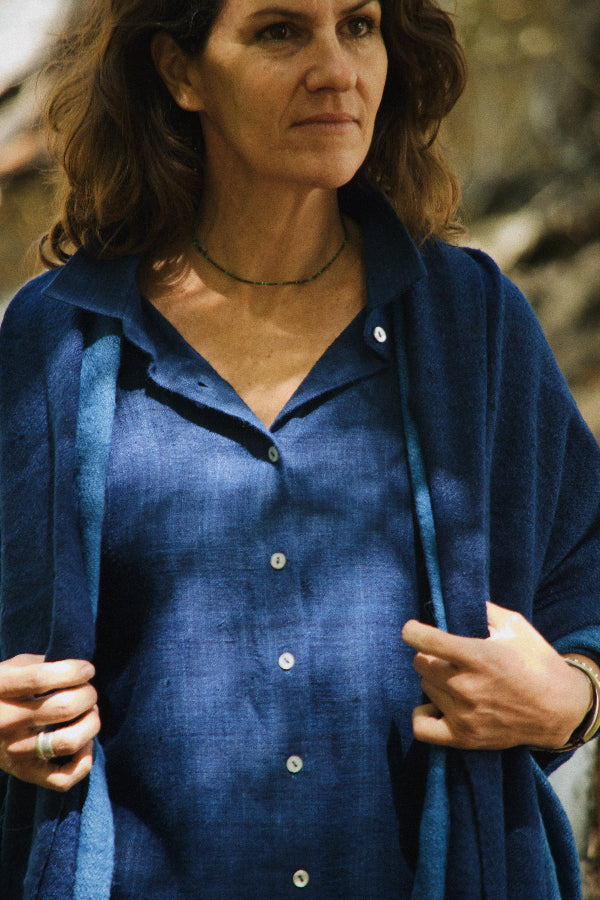 Woman wearing a blue shirt with a blurred natural background